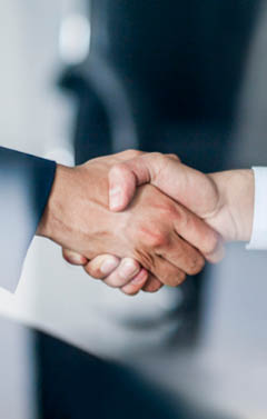 Business handshake in glass reflection in office