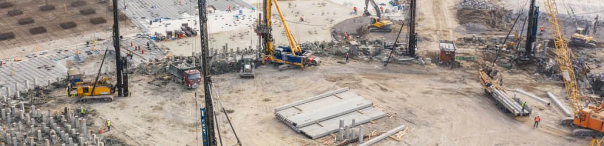 Huge excavation and foundation construction, drilling piles in urban development, aerial view