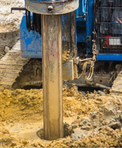 Hydraulic drilling machine is boring holes in the construction site for bored piles work. Bored piles are reinforced concrete elements cast into drilled holes, also known as replacement piles.