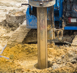 Hydraulic drilling machine is boring holes in the construction site for bored piles work. Bored piles are reinforced concrete elements cast into drilled holes, also known as replacement piles.